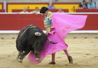 El novillero Rafael Cerro da un pase con el capote al segundo de su lote, durante la primera corrida de los Sanfermines