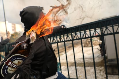 Un manifestante lanza una botella durante la protesta frente al Parlamento griego en Atenas.
