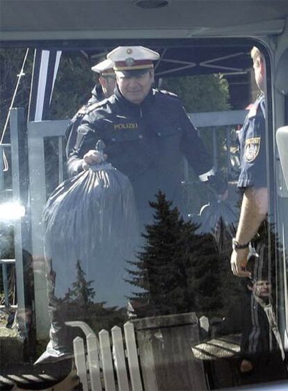 Un policía carga bolsas con indicios recogidos en la casa de Josef Fritzl en Amstetten (Austria).
