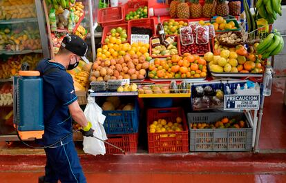 Un trabajador de limpieza desinfecta un mercado de Bogotá, el pasado 8 de julio.