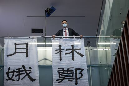 El legislador prodemócrata Lam Cheuk-ting despliega una banderola contra la jefa del Gobierno autónomo, Carrie Lam, dentro de la sede del parlamento de Hong Kong.