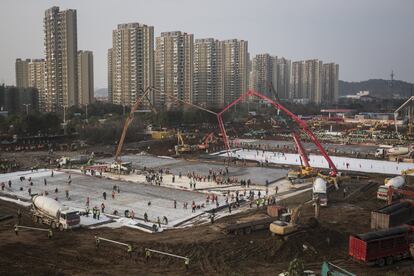 Cientos de trabajadores con ayuda de maquinaria pesada construyen un nuevo hospital para combatir el coronavirus, en Wuhan (China), el 28 de enero.