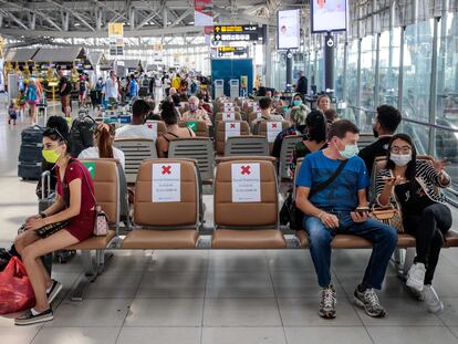 Viajeros llevando máscaras en el aeropuerto de Babkok y respetando la distancia de seguridad que indican los carteles, el 25 de marzo del 2020.