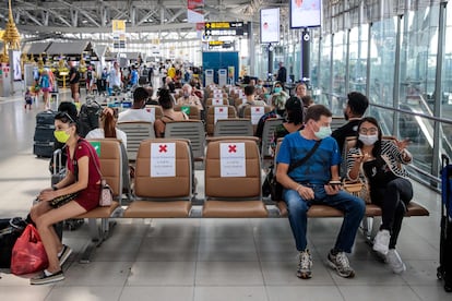 Viajeros llevando máscaras en el aeropuerto de Babkok y respetando la distancia de seguridad que indican los carteles, el 25 de marzo del 2020.