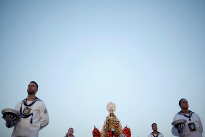 La Virgen del Carmen es escoltada por los marineros durante la procesión por las calles de Torremolinos.