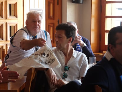 Ricardo Heyroth, 'El Alemán', como lo llaman en el pueblo de Los Molinos, bromea con un banderín del Real Madrid con uno de sus amigos del bar Los Ángeles, donde se juntan a ver los partidos del club merengue.