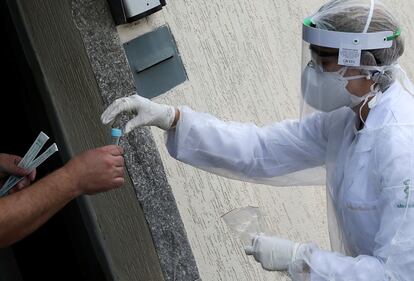 Homem recebe na terça, 14 de abril, um teste de coronavírus de um profissional da saúde na porta de sua casa, em São Caetano do Sul, São Paulo.