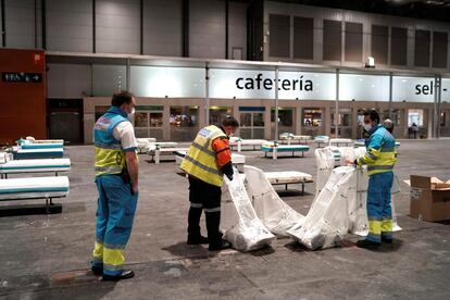 Empleados de la Comunidad de Madrid trabajan para acondicionar el pabellón 5 de Ifema como hospital provisional, en un intento de aliviar la presión de los hospitales de la región.