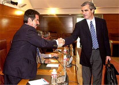 El presidente del PP cántabro, José Joaquín Martínez Sieso, a la derecha, saluda al líder del PRC, Miguel Ángel Revilla.