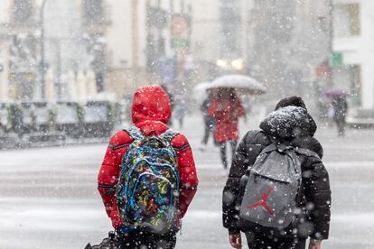 Dos niños caminan mientras nieva en Soria capital.