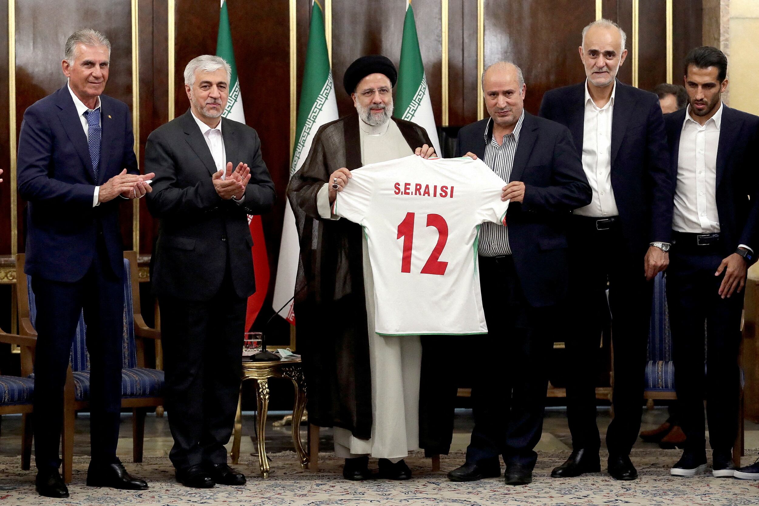 El presidente iraní, Ebrahim Raisí, sostiene una camiseta de la selección nacional durante una reunión con miembros del equipo nacional en Teherán,el 14 de noviembre de 2022.