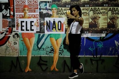 Una mujer se toma un selfie junto a un cartel de rechazo a Bolsonaro, el 29 de septiembre en São Paulo.