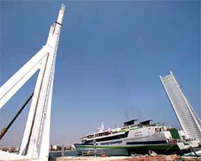 Un barco de pasajeros sale del Puerto de Valencia, ayer, a través del puente móvil construido para trenes.