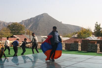 Niños desplazados del Alto Karabaj juegan con una bandera armenia en la ciudad armenia de Goris.