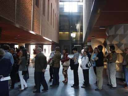 Un grupo de personas esperan para acceder al atrio del centro multicultural de la Alhóndiga.