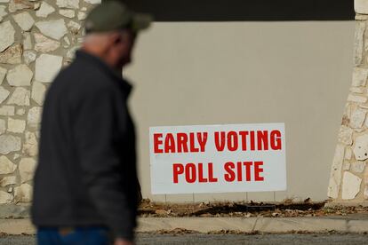A man passes an early voting poll site, Monday, Feb. 14, 2022, in San Antonio.