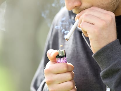 Un hombre enciende un cigarrillo en la calle con un mechero, en una imagen de archivo.