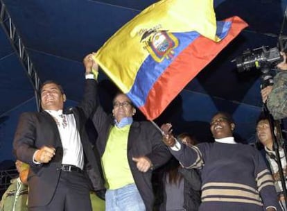 Correa (izquierda) y Acosta (a su derecha) muestran una bandera ecuatoriana a los seguidores congregados para celebrar la victoria.