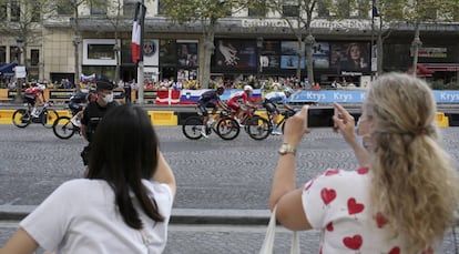 Seguidoras del Tour al paso del pelotón por las calles de París, este domingo. Debido al coronavirus, el acceso a los Campos Elíseos se ha restringido a un máximo de 5.000 espectadores.