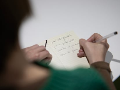 Una mujer escribe en una libreta.