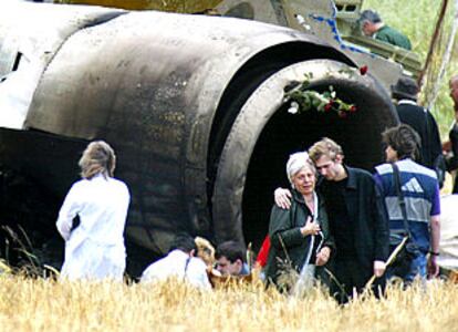 Familiares de las víctimas del avión ruso que se estrelló en el sur de Alemania, ayer, junto a los restos del Tupolev 154.