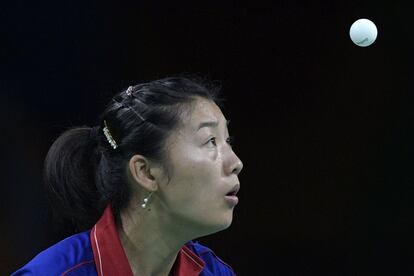 La francesa Li Xue fija sus ojos en la pelota mientras juega contra la alemana Han Ying durante la clasificación femenina de tenis de mesa, en los Juegos de Río 2016.