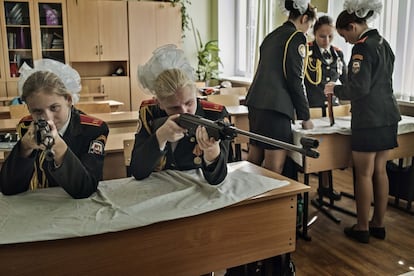 Um grupo de meninas aprende a montar rifles na Academia de Cadetes de Moscou.