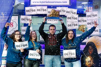 El lotero Víctor Fernández celebra este lunes con cava junto a sus empleadas el haber vendido una serie del segundo premio del sorteo extraordinario de El Niño, el número 06766, en la administración del centro comercial de Las Arenas en Barcelona. 
