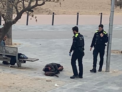 Dos agentes, ante el hombre agredido en la Barceloneta.