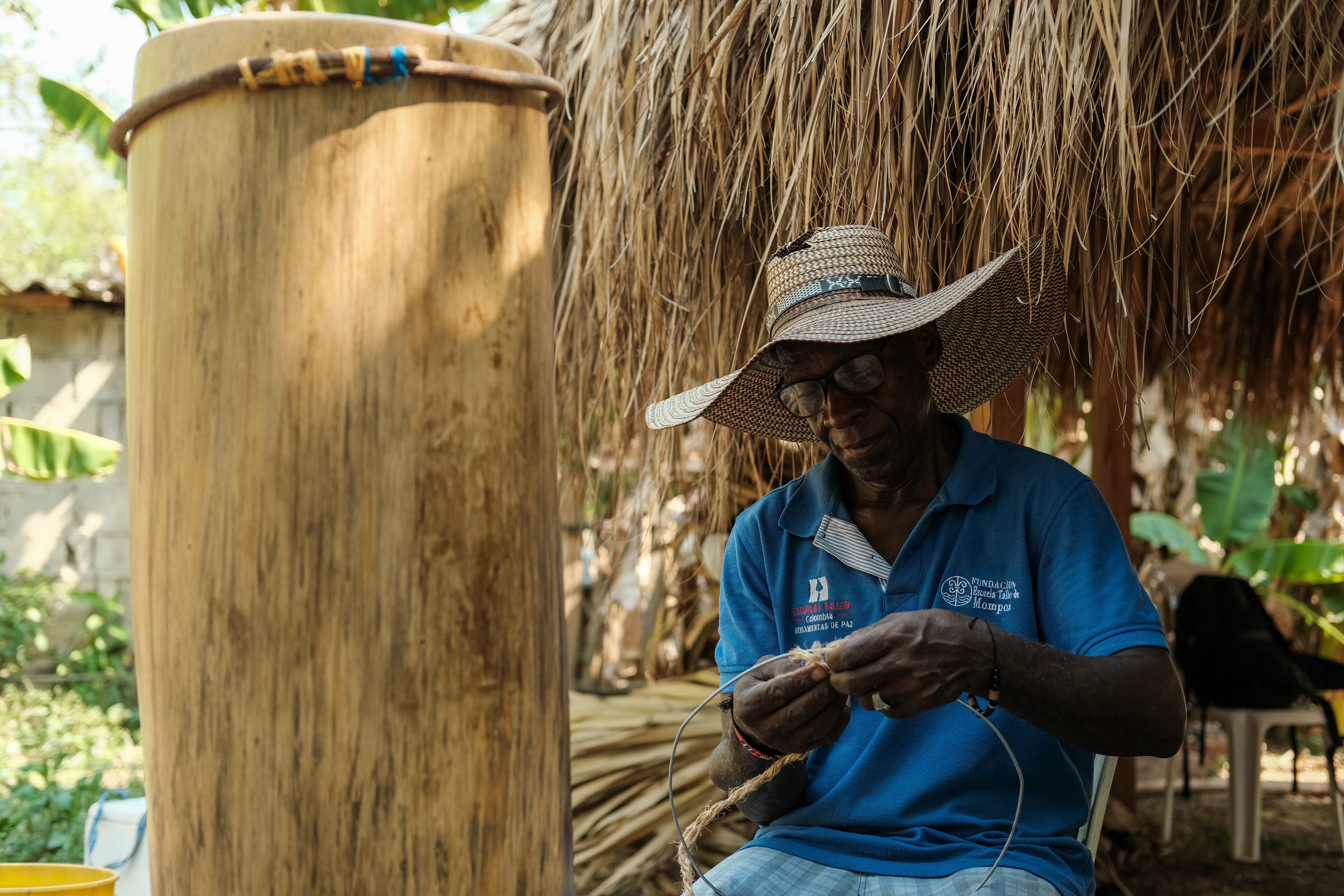 Un hombre construye aros de madera para dar soporte a piel y cuerdas del tambor.