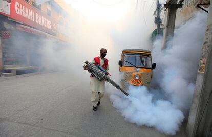 Un trabajador municipal fumiga las calles de Rawalpindi, Pakistán, para prevenir que enfermedades como el dengue u otras provocadas por picaduras de mosquito se propaguen. 