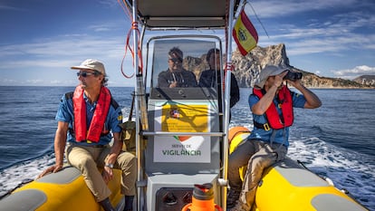 Los agentes medioambientales Carlos Palacios (con prismáticos) y Mariano Bermejo, en una salida de vigilancia en el mar en la zona de Calpe (Alicante), hace unos días.