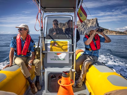 Los agentes medioambientales Carlos Palacios (con prismáticos) y Mariano Bermejo, en una salida de vigilancia en el mar en la zona de Calpe (Alicante), hace unos días.