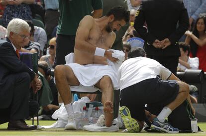 Marin Cilic recibe tratamiento médico en el pie durante el partido ante Roger Federer.