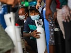Men wearing protective face masks wait outside a store with their oxygen cylinders to get them refilled, amid a surge of coronavirus disease (COVID-19) cases, in Surabaya, East Java Province, Indonesia July 12, 2021, in this photo taken by Antara Foto. Didik Suhartono/Antara Foto via REUTERS  ATTENTION EDITORS - THIS IMAGE WAS PROVIDED BY THIRD PARTY. MANDATORY CREDIT. INDONESIA OUT.