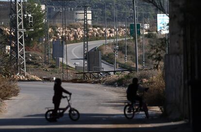Dos niñas palestinas montan en bicicleta en Nabi Saleh, el pueblo de Wisam Tamimi. Al fondo, la carretera del asentamiento ilegal de colonos de Halamish, por donde los palestinos tienen prohibido circular.