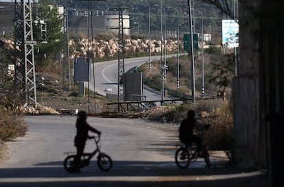 Dos niños palestinos juegan ante la carretera que lleva al asentamiento israelí de Ateret, por donde tienen prohibido circular los palestinos.