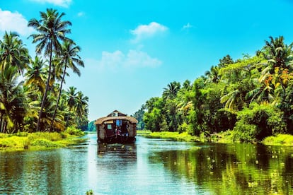 Un barco-vivienda atraviesa uno de los canales navegables del Estado de Kerala, al sur de la India.