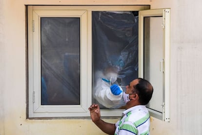 Un sanitario toma una muestra para detectar coronvirus en un dispensario de Nueva Delhi (India).