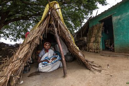 Dodakka, de 20 años, es de la casta kadugolla y vive en la aldea de Gollarahatti, en el Estado de Andhra Pradesh. En la imagen, acuna a su primogénita, que tiene mes y medio. Ese es también el tiempo que llevan viviendo en la choza de la imagen, junto a la casa familiar. No pueden entrar en esta porque ofenderían a los dioses, sus paseos están restringidos a cuatro o cinco metros a la redonda y nadie puede tocarlas porque, según la superstición kadugolla, también serían contaminados.