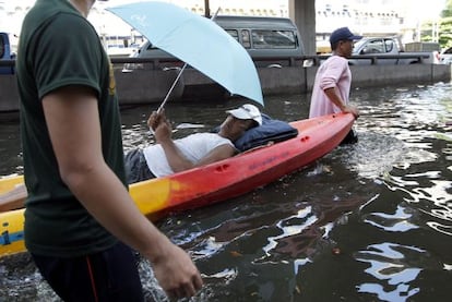 Un hombre enfermo es evacuado en barca  en Bangkok (Tailandia).