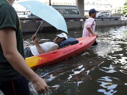 Un hombre enfermo es evacuado en barca  en Bangkok (Tailandia).