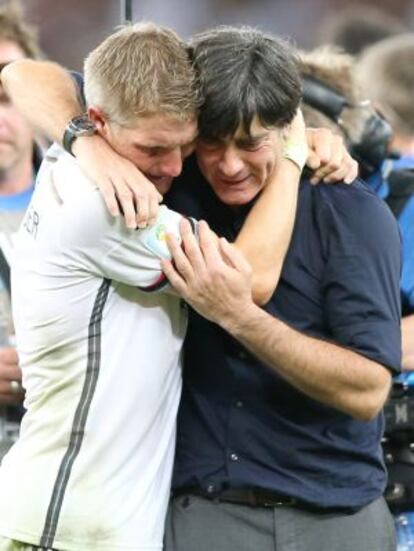 L&ouml;w se abraza con Schweinsteiger tras ganar. 