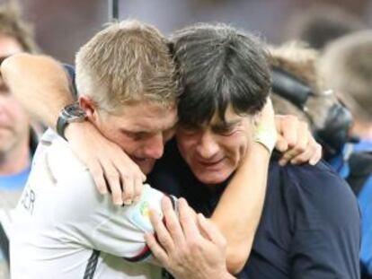 L&ouml;w se abraza con Schweinsteiger tras ganar. 