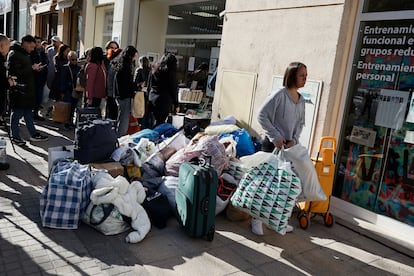 Numerosas personas se han acercado a dejar ropa, mantas y calzado para los vecinos afectados por el incendio, este viernes en Valencia.