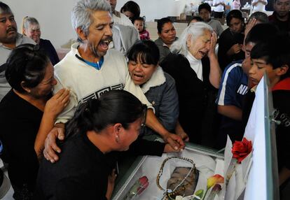 Ismael Reyes llora, junta a otros familiares, delante del ataúd de su hijo, Ismael Reyes Ricardo, de 22 años, asesinado durante la fiesta familiar de cumpleaños.