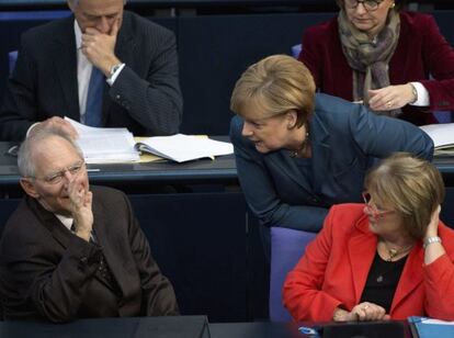 Merkel habla con Sch&auml;uble, en el Bundestag.