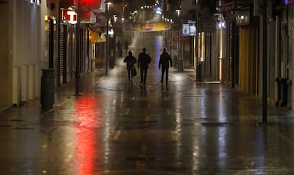 Varias personas caminan por una calle de Ronda, minutos antes del toque de queda.