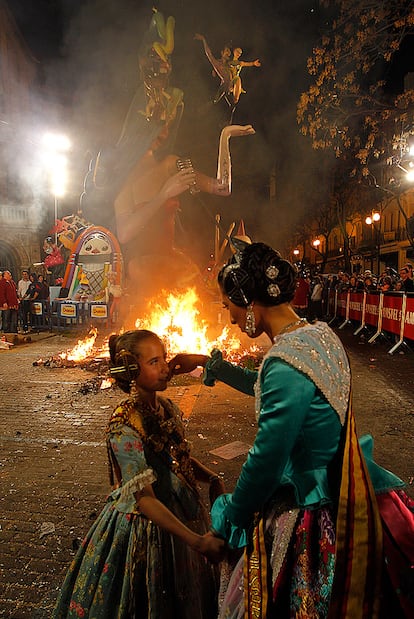 Una mujer consuela a una niña al comienzo de la quema de la falla de la plaza del Mercat.