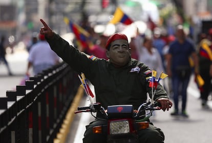 Un simpatizante caracterizado como Hugo Chávez recorre la marcha a borde de una motocicleta, este sábado en Caracas (Venezuela).